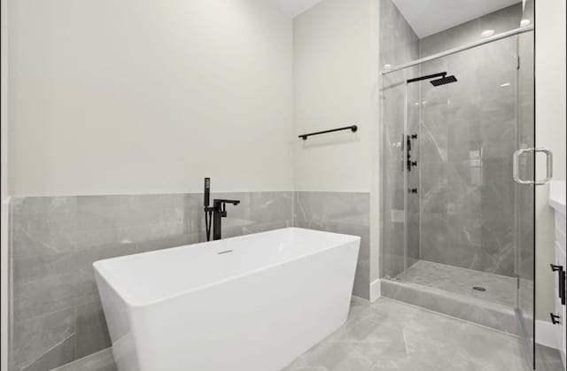 5935 Cebra, Houston, TX 77091 - bathroom with a freestanding tub, a stall shower, tile walls, a wainscoted wall, and marble finish flooring