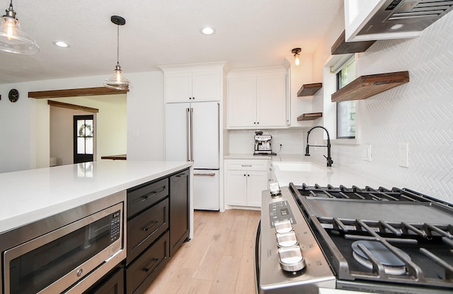 2826 Durban Dr, Houston, TX 77043 - kitchen featuring built in appliances, open shelves, white cabinets, exhaust hood, and light countertops