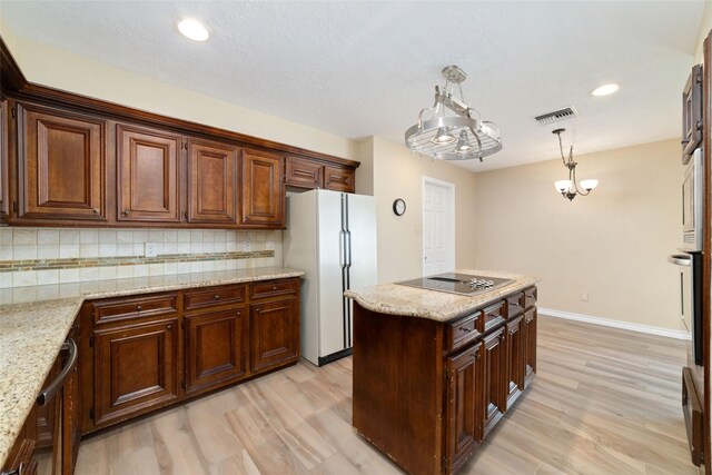 7238 N Hearthstone Green Dr, Houston, TX 77095 - kitchen with freestanding refrigerator, black electric cooktop, light wood-style floors, tasteful backsplash, and recessed lighting