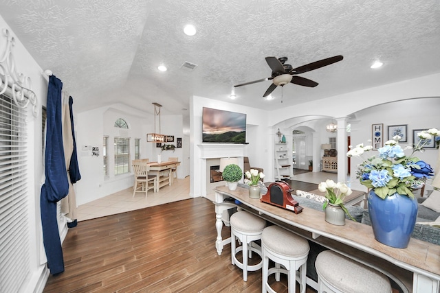 5231 S Fm 565th Rd, Cove, TX 77523 - dining space featuring ornate columns, arched walkways, ceiling fan, wood finished floors, and a textured ceiling