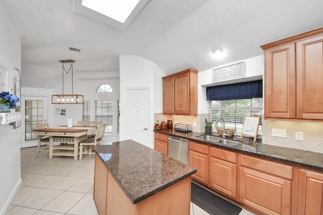 5231 S Fm 565th Rd, Cove, TX 77523 - kitchen featuring stainless steel dishwasher, lofted ceiling, plenty of natural light, dark stone countertops, and light tile patterned floors