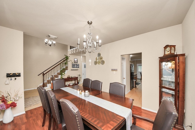 20310 Port Bishop Ln, Richmond, TX 77407 - dining area featuring a chandelier, stairs, and wood finished floors