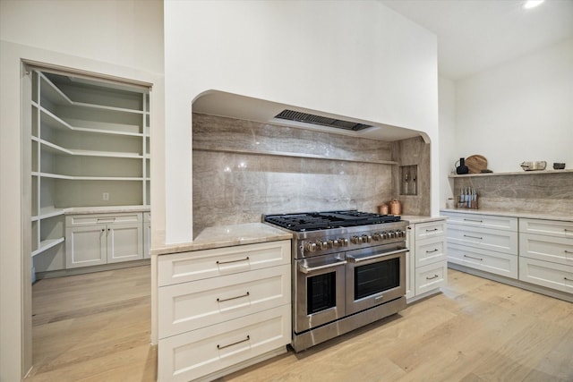 6227 Grovewood Ln, Houston, TX 77008 - kitchen featuring double oven range, light wood-style floors, decorative backsplash, and light stone counters