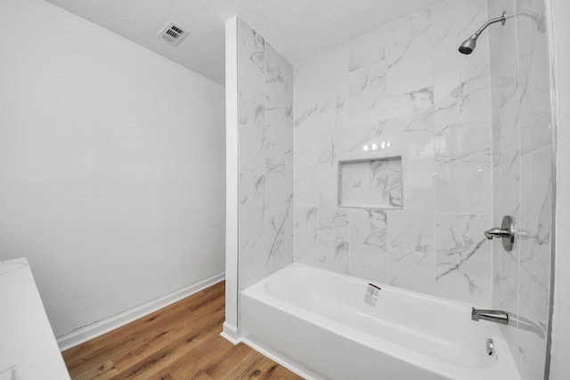 9250 Wiloak St, Houston, TX 77028 - bathroom featuring washtub / shower combination and wood finished floors