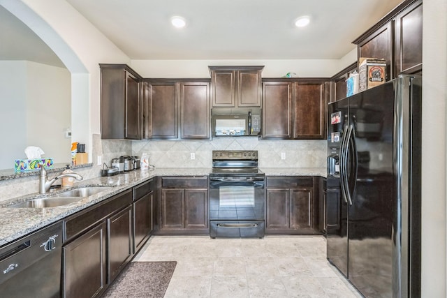 6328 Dorothy Muree Dr, Temple, TX 76502 - kitchen featuring black appliances, arched walkways, light stone countertops, dark brown cabinets, and tasteful backsplash