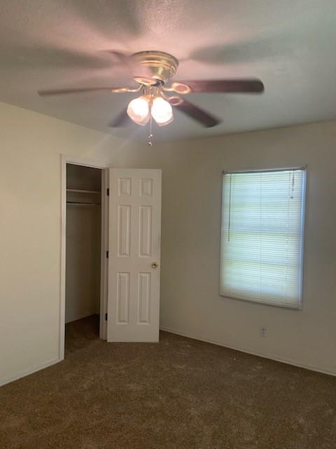5514 Borden Ave, Galveston, TX 77551 - unfurnished bedroom featuring carpet flooring, a closet, and ceiling fan