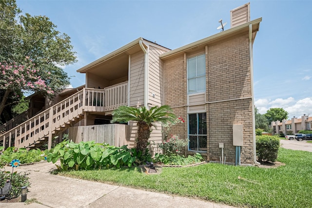 1505 Ward Rd Unit 118, Baytown, TX 77520 - view of side of property with brick siding, stairway, a chimney, and a lawn