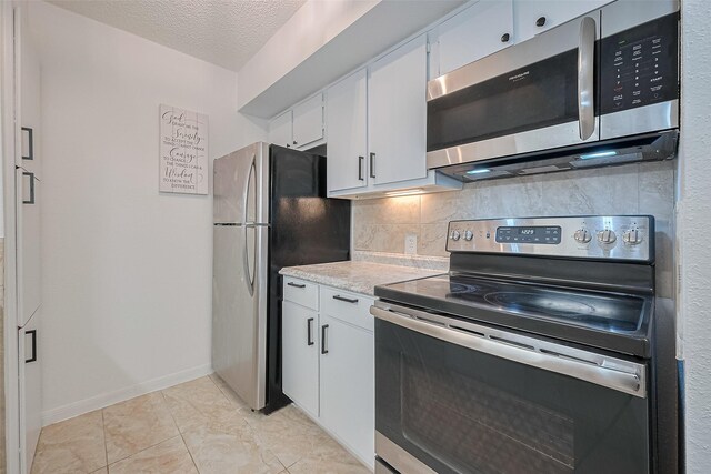1505 Ward Rd Unit 118, Baytown, TX 77520 - kitchen with stainless steel appliances, backsplash, light countertops, white cabinetry, and a textured ceiling