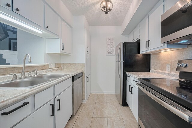 1505 Ward Rd Unit 118, Baytown, TX 77520 - kitchen featuring stainless steel appliances, light countertops, white cabinetry, a textured ceiling, and backsplash