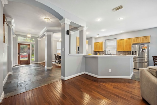 5715 Ashley Spring Ct, Katy, TX 77494 - kitchen with stainless steel fridge, a peninsula, decorative columns, open floor plan, and backsplash
