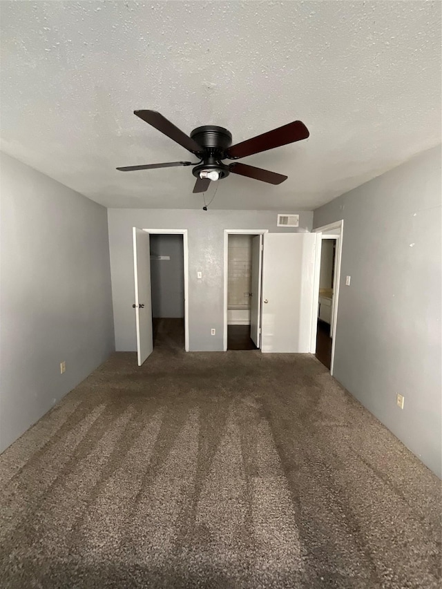 7200 Clarewood Dr Unit 10, Houston, TX 77036 - unfurnished bedroom with ensuite bath, a spacious closet, carpet floors, a ceiling fan, and a textured ceiling