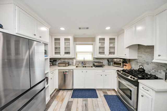 5422 Jason St, Houston, TX 77096 - kitchen featuring stainless steel appliances, backsplash, white cabinets, and recessed lighting