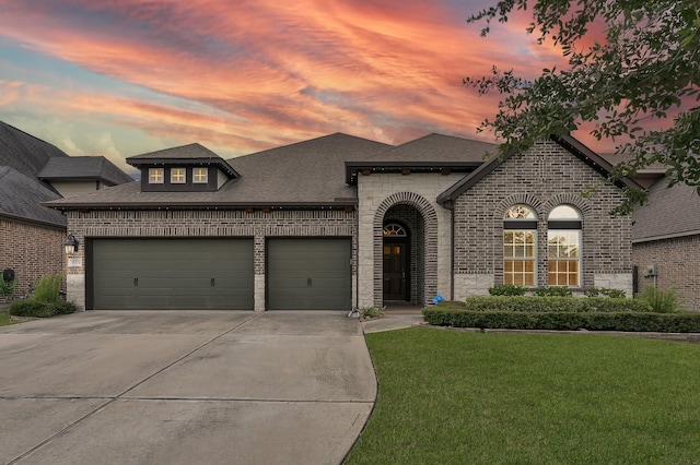 31276 New Forest Park Ln, Spring, TX 77386 - french country inspired facade featuring brick siding, driveway, an attached garage, and a lawn