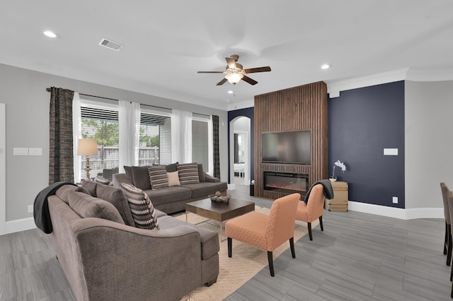 31276 New Forest Park Ln, Spring, TX 77386 - living area featuring ceiling fan, recessed lighting, a large fireplace, arched walkways, and crown molding