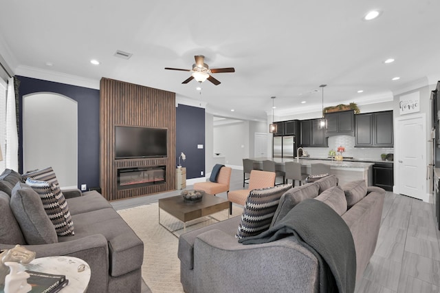 31276 New Forest Park Ln, Spring, TX 77386 - living area with crown molding, recessed lighting, a ceiling fan, and a glass covered fireplace