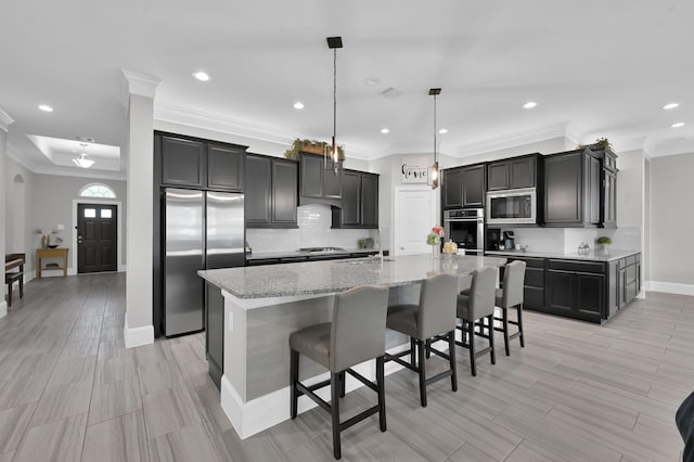 31276 New Forest Park Ln, Spring, TX 77386 - kitchen with appliances with stainless steel finishes, crown molding, decorative backsplash, a large island, and light stone counters