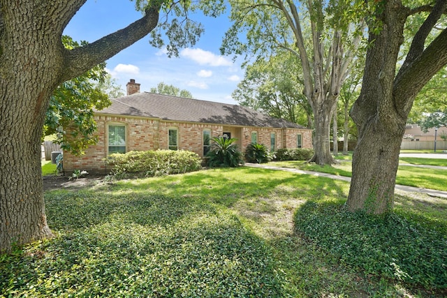 3103 Fairway Dr, Sugar Land, TX 77478 - ranch-style house featuring a chimney, brick siding, a front lawn, and roof with shingles