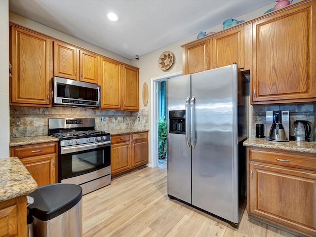 3219 Almond Creek Dr, Houston, TX 77059 - kitchen featuring appliances with stainless steel finishes, backsplash, and brown cabinetry