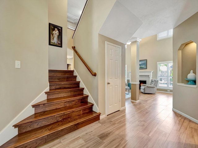 3219 Almond Creek Dr, Houston, TX 77059 - stairs with wood finished floors, a warm lit fireplace, and a high ceiling