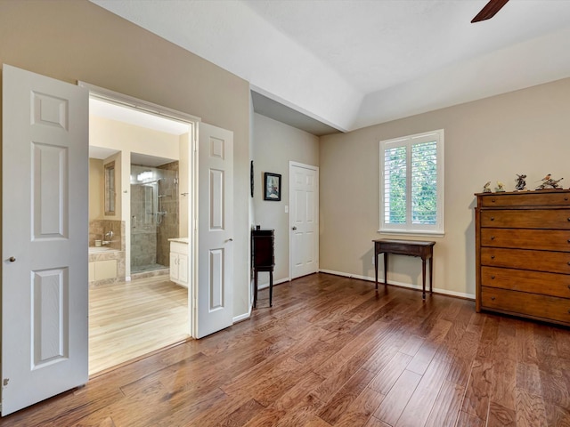 3219 Almond Creek Dr, Houston, TX 77059 - bedroom with wood finished floors, connected bathroom, and vaulted ceiling