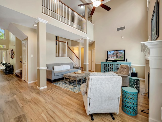 3219 Almond Creek Dr, Houston, TX 77059 - living room featuring stairway, a towering ceiling, ornate columns, a ceiling fan, and wood finished floors