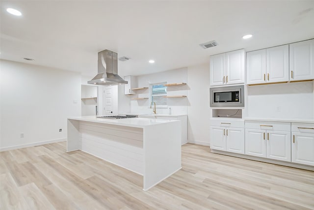 7226 Troulon Dr, Houston, TX 77074 - kitchen featuring ventilation hood, stainless steel microwave, open shelves, white cabinets, and recessed lighting