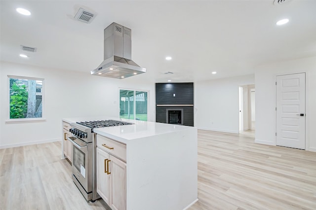 7226 Troulon Dr, Houston, TX 77074 - kitchen featuring gas stove, island range hood, light wood finished floors, a kitchen island, and recessed lighting