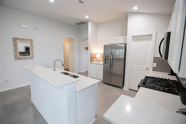 6926 Glenmoor Dr, Rosharon, TX 77583 - kitchen featuring appliances with stainless steel finishes, arched walkways, white cabinets, light tile patterned flooring, and recessed lighting