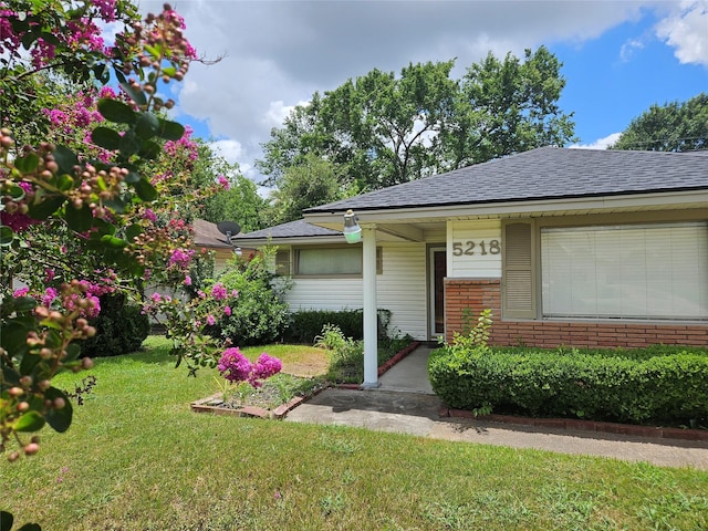5218 Cortelyou Ln, Houston, TX 77021 - view of front of home with a front yard, brick siding, and roof with shingles