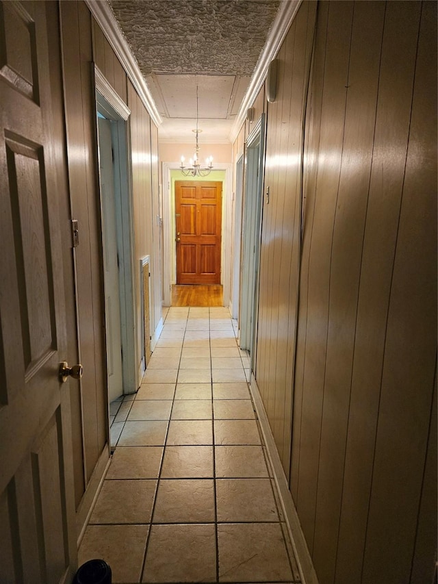 5218 Cortelyou Ln, Houston, TX 77021 - hall with a chandelier, crown molding, wooden walls, and light tile patterned floors