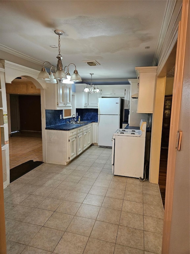 5218 Cortelyou Ln, Houston, TX 77021 - kitchen featuring white appliances, a chandelier, arched walkways, crown molding, and light tile patterned floors