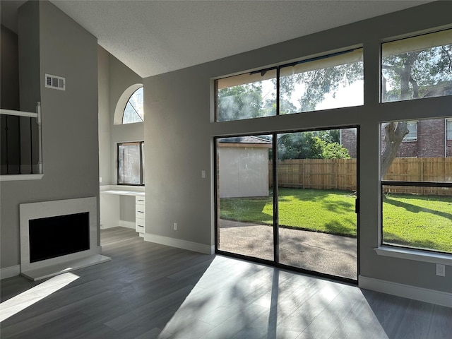 2922 Field Line Dr, Sugar Land, TX 77479 - doorway to outside featuring wood finished floors, high vaulted ceiling, and a textured ceiling
