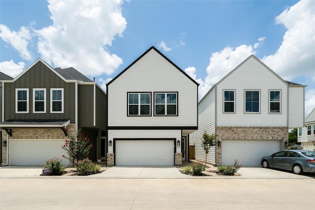 11325 Stonework Garden Ln, Houston, TX 77076 - view of front facade with an attached garage, concrete driveway, board and batten siding, and brick siding