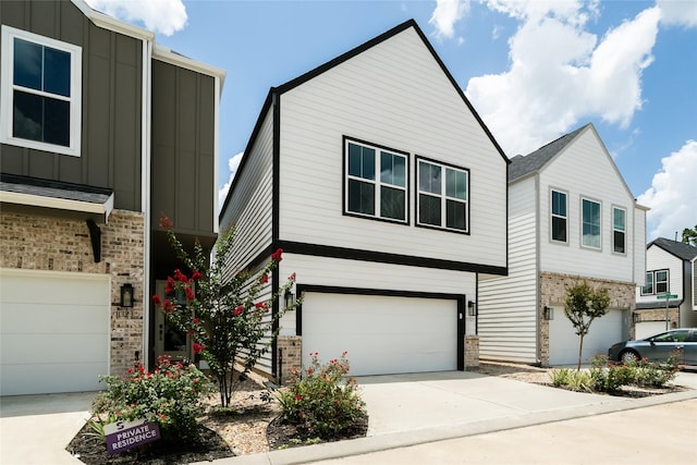 11325 Stonework Garden Ln, Houston, TX 77076 - view of front facade featuring board and batten siding, brick siding, an attached garage, and driveway