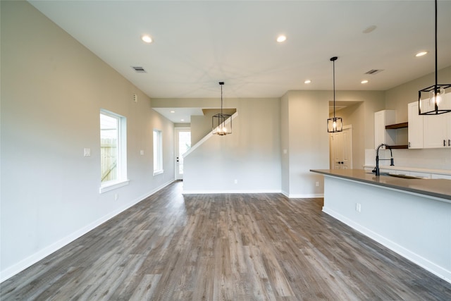 11325 Stonework Garden Ln, Houston, TX 77076 - kitchen featuring recessed lighting, white cabinets, wood finished floors, pendant lighting, and dark countertops