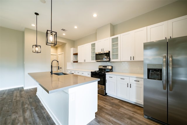 11325 Stonework Garden Ln, Houston, TX 77076 - kitchen featuring stainless steel appliances, a center island with sink, dark wood-type flooring, decorative backsplash, and white cabinets