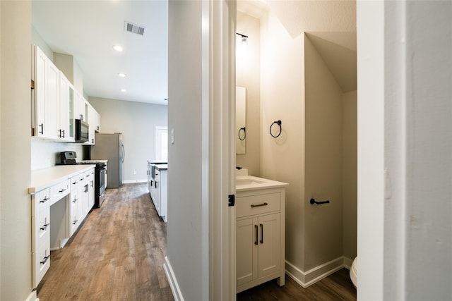 11325 Stonework Garden Ln, Houston, TX 77076 - full bath with two vanities, wood finished floors, and recessed lighting