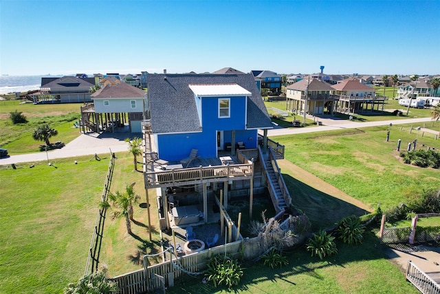 862 Gregory Ln, Port Bolivar, TX 77650 - back of property featuring a residential view, a shingled roof, stairs, and a wooden deck