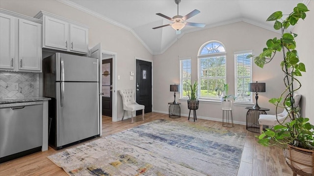 4542 Shallow Ember Dr, Spring, TX 77386 - kitchen featuring appliances with stainless steel finishes, light wood-style flooring, a ceiling fan, lofted ceiling, and decorative backsplash