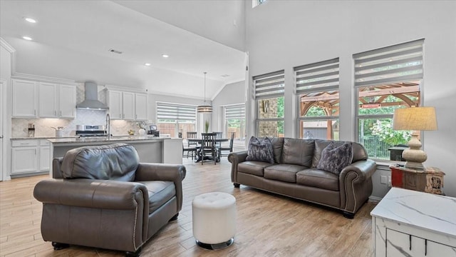 4542 Shallow Ember Dr, Spring, TX 77386 - living room featuring plenty of natural light, light wood-style flooring, a high ceiling, and recessed lighting