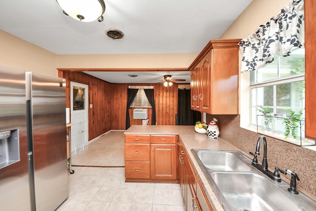 418 Forrest St, Baytown, TX 77520 - kitchen featuring stainless steel fridge with ice dispenser, brown cabinets, a ceiling fan, a peninsula, and wood walls