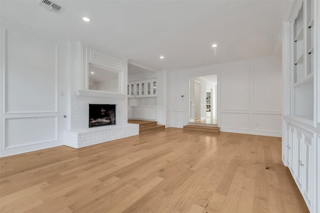 13631 Balmore Cir, Houston, TX 77069 - unfurnished living room with a decorative wall, a fireplace, light wood finished floors, recessed lighting, and ornamental molding