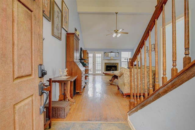 5651 Pine St, Houston, TX 77081 - entryway featuring a fireplace with raised hearth, ceiling fan, stairs, light wood-style flooring, and high vaulted ceiling