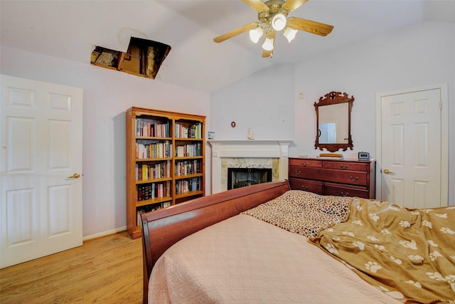 5651 Pine St, Houston, TX 77081 - bedroom with a premium fireplace, light wood-style flooring, lofted ceiling, and a ceiling fan