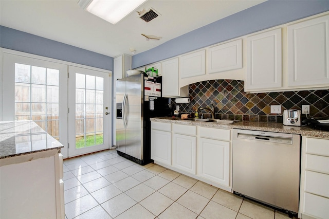 5651 Pine St, Houston, TX 77081 - kitchen with dishwashing machine, stainless steel fridge, tasteful backsplash, white cabinetry, and light tile patterned flooring