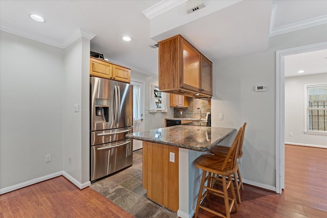 4206 Law St, Houston, TX 77005 - kitchen with stainless steel refrigerator with ice dispenser, ornamental molding, a kitchen breakfast bar, decorative backsplash, and dark stone countertops