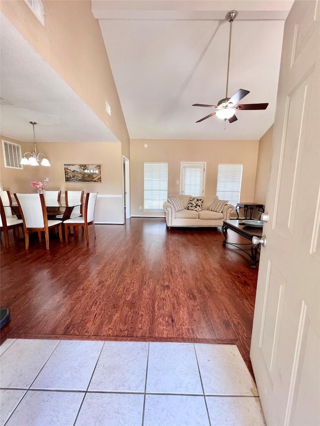 18738 Shannon Glen Ln, Houston, TX 77084 - tiled living room with a ceiling fan, a chandelier, and high vaulted ceiling