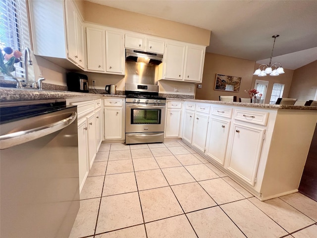 18738 Shannon Glen Ln, Houston, TX 77084 - kitchen featuring appliances with stainless steel finishes, under cabinet range hood, plenty of natural light, and a peninsula