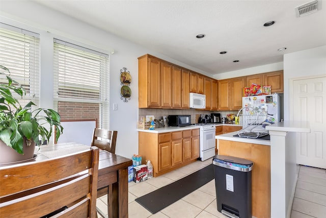 25603 Myrtle Spgs, Spring, TX 77373 - kitchen with white appliances, light countertops, light tile patterned flooring, backsplash, and a kitchen island