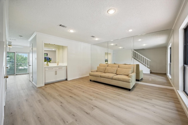 33 Lakewood Ln, Seabrook, TX 77586 - living area with a textured ceiling, light wood finished floors, ornamental molding, stairway, and recessed lighting